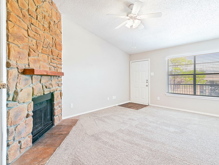 Carpeted Living Room at Terrace at Bookstone and Terrace Apartments in Irving, Texas